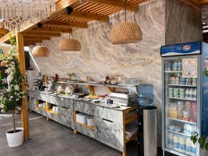 a restaurant kitchen with a counter with food at Ilio Boutique Hotel in Ksamil