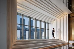 a woman standing in a room with large windows at ISEYA Panoramic Hotel Chongqing Jiefangbei Raffles Plaza in Chongqing