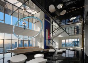 a lobby with a bunch of stools in a building at ISEYA Panoramic Hotel Chongqing Jiefangbei Raffles Plaza in Chongqing