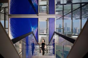 a woman and a man standing on a balcony in a building at ISEYA Panoramic Hotel Chongqing Jiefangbei Raffles Plaza in Chongqing