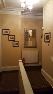 a hallway with a mirror on the wall and a staircase at Locomotion in Eaglescliffe