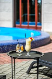 a table with a drink on top of it at Hotel Golden Palace in Göd