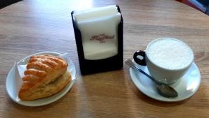 a table with a plate of food and a cup of coffee at La Marmotta in Luserna San Giovanni +9 photos
