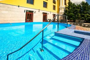 a swimming pool with stairs and a building at Hotel Golden Palace in Göd +189 photos