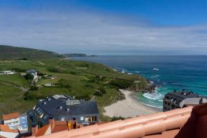 a view of a beach with houses and the ocean at GARA MALPICA, terraza al mar in Malpica