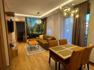 a living room with a table and a dining room at Apartmani Didić Kalman Zlatibor in Zlatibor