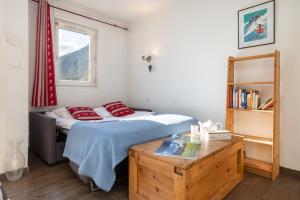 una camera da letto con un letto con cuscini rossi di Chamonix Sud - Rivière 401 - Happy Rentals a Chamonix-Mont-Blanc