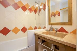 un bagno con un lavandino, uno specchio e una vasca di Chamonix Sud - Rivière 401 - Happy Rentals a Chamonix-Mont-Blanc