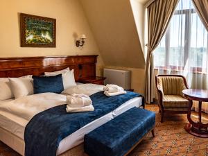 a hotel room with a bed with towels on it at Hotel Golden Palace in Göd