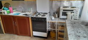 a small kitchen with a stove and a microwave at Leruk Maasai Mara Camp in Sekenani