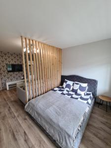 una camera da letto con un letto con testiera in legno di Butterfly apartment a Šiauliai Altre 19 foto