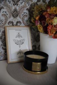 una candela e un'immagine accanto a un portacandele di Butterfly apartment a Šiauliai