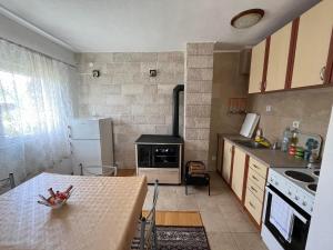 a kitchen with a table and a stove top oven at Kuća Čepić in Žabljak +17 photos