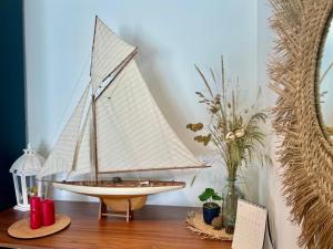a wooden sail boat sitting on a wooden table at jolie résidence proche du centre ville à Roscoff in Roscoff
