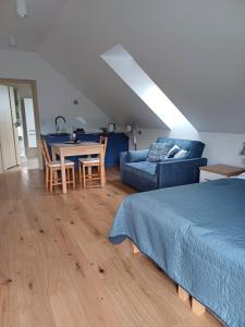 a bedroom with a bed and a table and a couch at APARTAMENTY BAŁTYCKA 4d in Rowy
