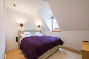 a bedroom with a bed with a purple blanket at Wave Apartments Szentendre in Szentendre