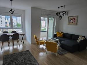 a living room with a couch and a table with chairs at Apartment Noa in Tuzla