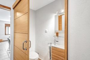 a bathroom with a toilet and a wooden door at Cal Ton in San Quírico Safaja +18 photos