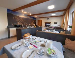 a dining room with a table with dishes on it at Frühstückspension Sport Mayr in Söll