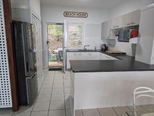 a kitchen with white cabinets and a black counter top at Villa 36 Tangalooma in Tangalooma