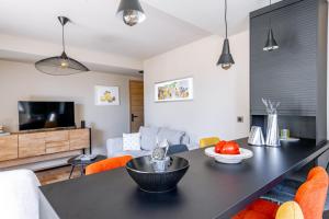 a living room with a black table and orange chairs at KM2 in Bédoin