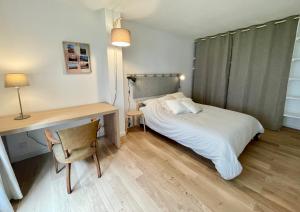 a bedroom with a bed and a desk and a chair at Le Refuge Marin in Dieppe +15 photos