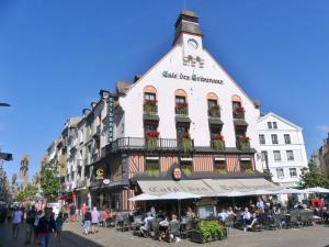 a large white building with people sitting outside of it at Le Refuge Marin in Dieppe