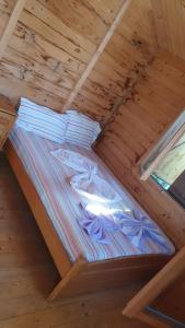 a bed in a room with a wooden ceiling at Camere Orizont in Costinesti