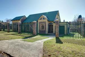 a house with a gate and a fence at Mrs Simpson in Dullstroom