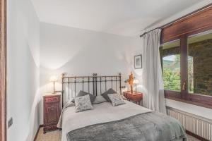 Un dormitorio con una cama grande y una ventana. en Casa Gran, en Sant Quirze Safaja