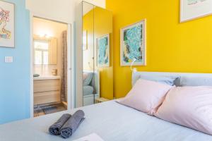 a bedroom with a bed with a yellow wall at T2 avec balcon à Malmousque - Calme & vue mer in Marseille