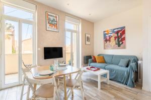a living room with a blue couch and a table at T2 avec balcon à Malmousque - Calme & vue mer in Marseille