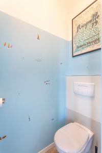 a bathroom with a toilet and a picture on the wall at T2 avec balcon à Malmousque - Calme & vue mer in Marseille +13 photos