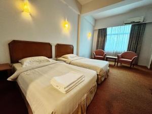 Postel nebo postele na pokoji v ubytování Grand Topaz Hotel