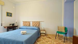 a bedroom with a blue bed and a green chair at Al Pianotto, appartamento vintage ad Avola, vista Mare in Avola