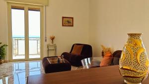 a living room with a table and chairs and a vase at Al Pianotto, appartamento vintage ad Avola, vista Mare in Avola