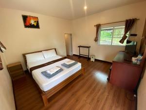 a bedroom with a large bed and a window at YaithiengHill Resort ยายเที่ยงฮิลล์ รีสอร์ท in Ban Khanan Chit +7 photos