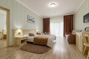 a bedroom with a bed and a table and a couch at Hotel Podgorie Spa in Bukovel