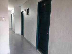 a row of black doors in a hallway at Ralik Hostel in Naga