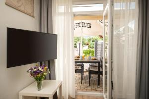a living room with a television and a table with flowers at Apartman Margareta in Matulji