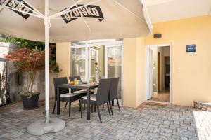 a table and chairs under an umbrella on a patio at Apartman Margareta in Matulji +17 photos