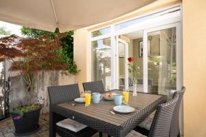 a wooden table with plates of food on a patio at Apartman Margareta in Matulji