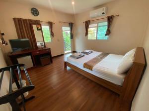 a bedroom with a bed and a television in it at YaithiengHill Resort ยายเที่ยงฮิลล์ รีสอร์ท in Ban Khanan Chit
