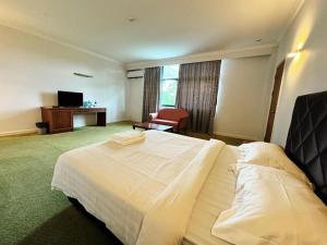 Postel nebo postele na pokoji v ubytování Grand Topaz Hotel