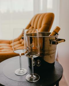 a table with two glasses and a bottle of wine at Vanagu muiža in Aizupes