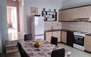 a kitchen with a table with a bowl of fruit on it at Ανδρος Αρκουδα in Andros