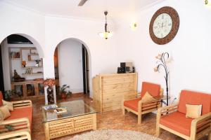 a living room with orange chairs and a glass table at Villa Baywalk Goa - 200 meters from Morjim Beach in Morjim