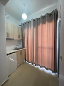 a kitchen with a shower curtain and a sink at Keivi Guesthouse in Sarandë
