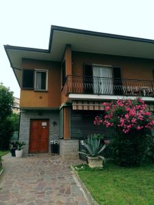 a house with a red door and a balcony at Casa Vacanze Mari, Paratico in Paratico