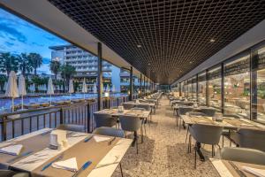 a restaurant with tables and chairs on a balcony at Royal Garden Beach Hotel in Konaklı